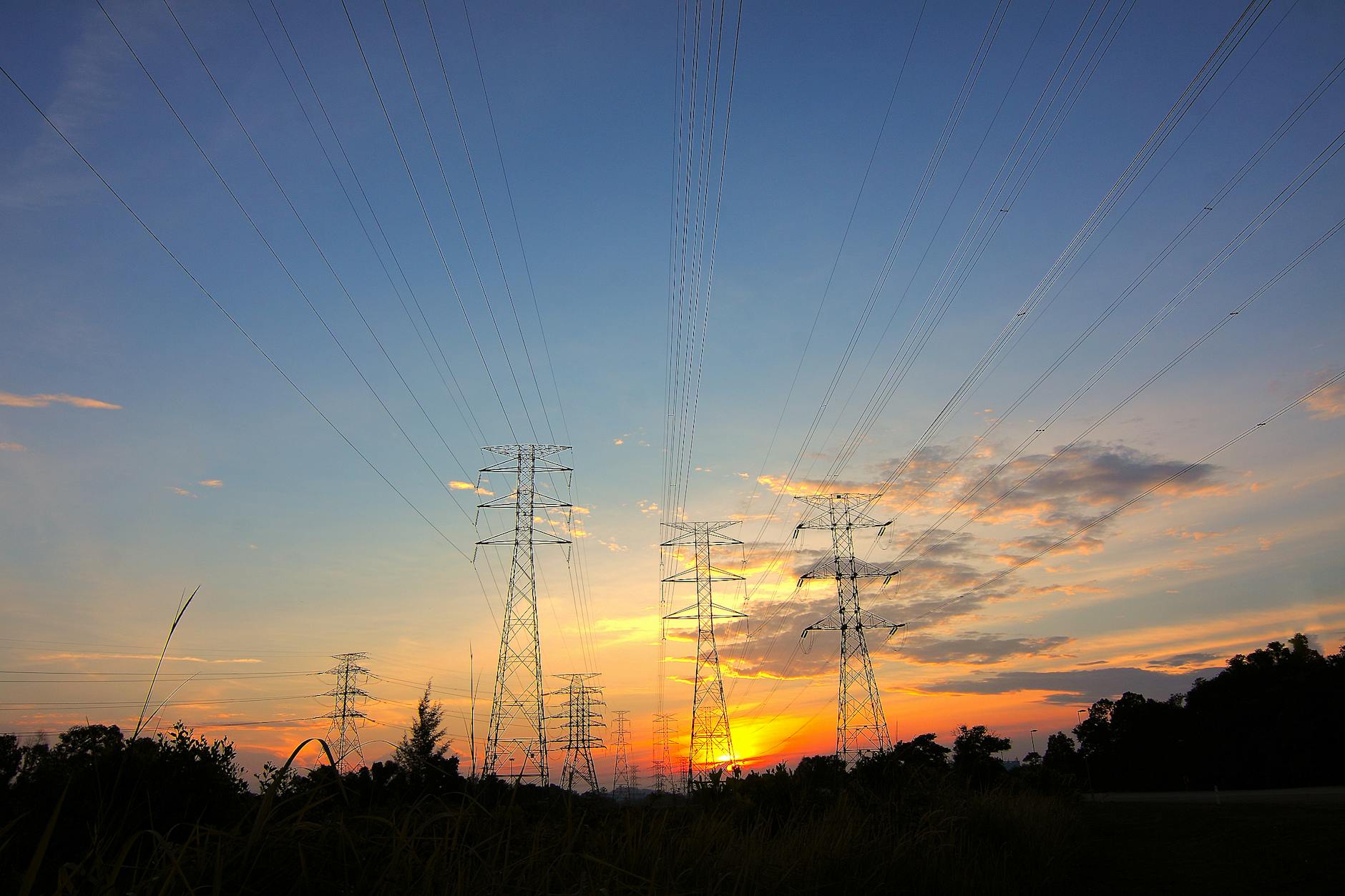 three black metal electricity posts during golden hour
