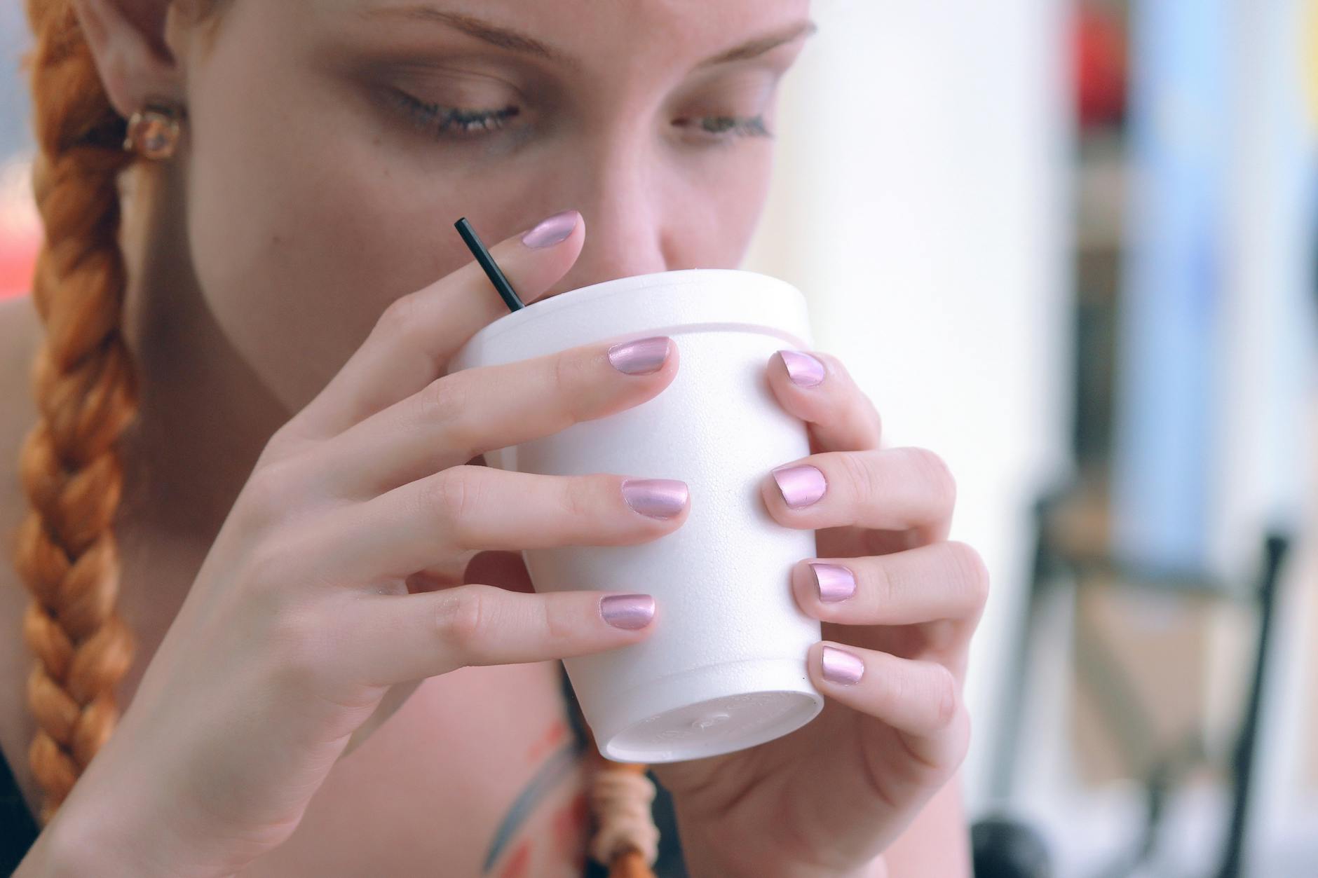 girl drinking from white cup