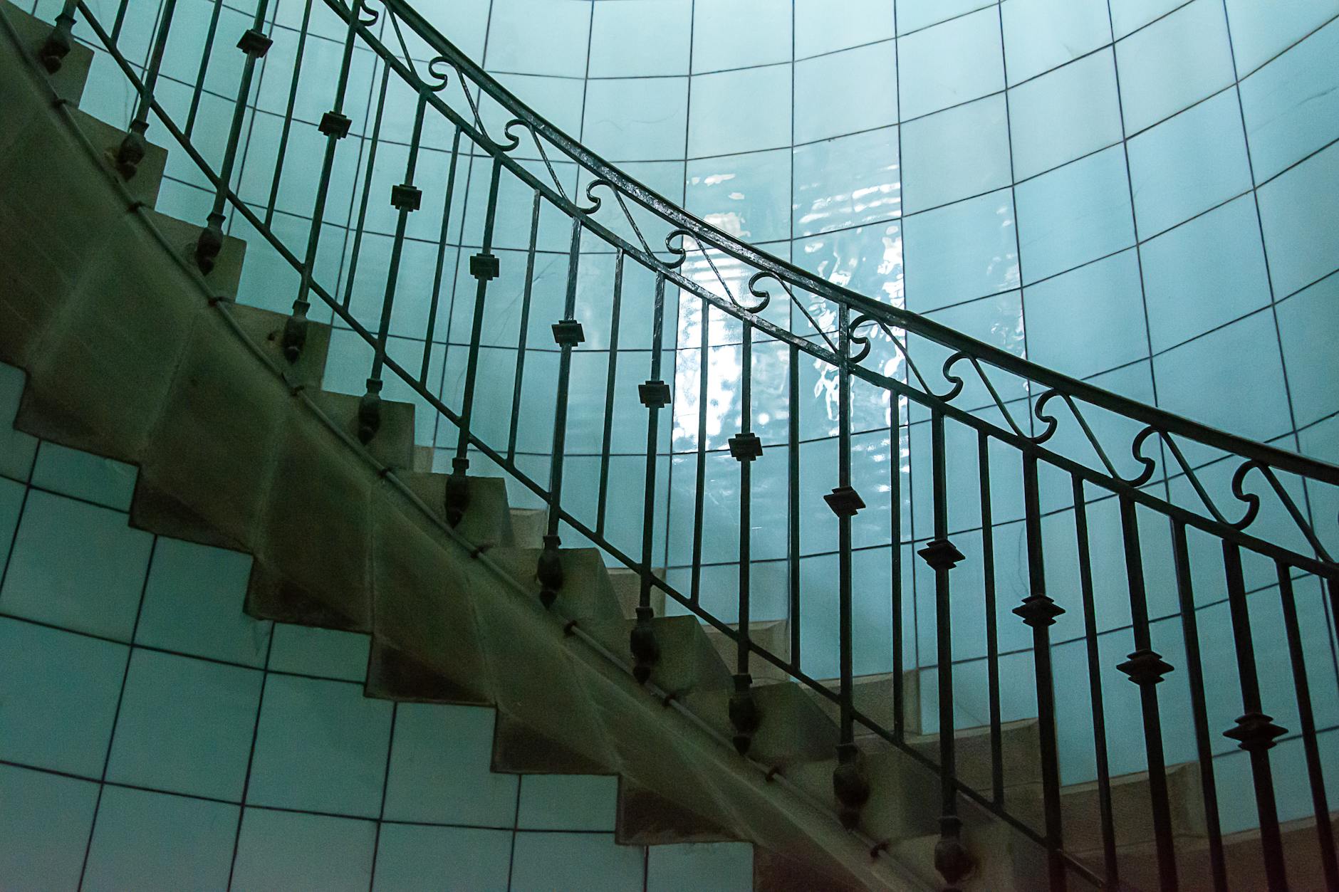 elegant spiral staircase with blue tiled wall