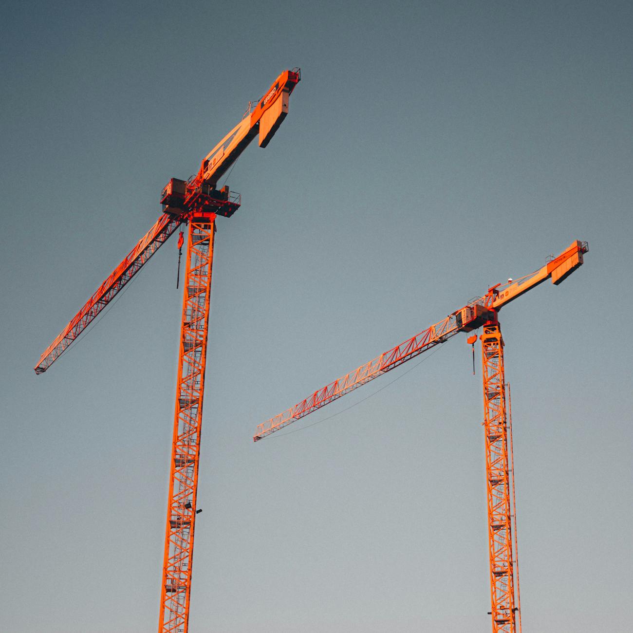 tower cranes against clear sky at dusk