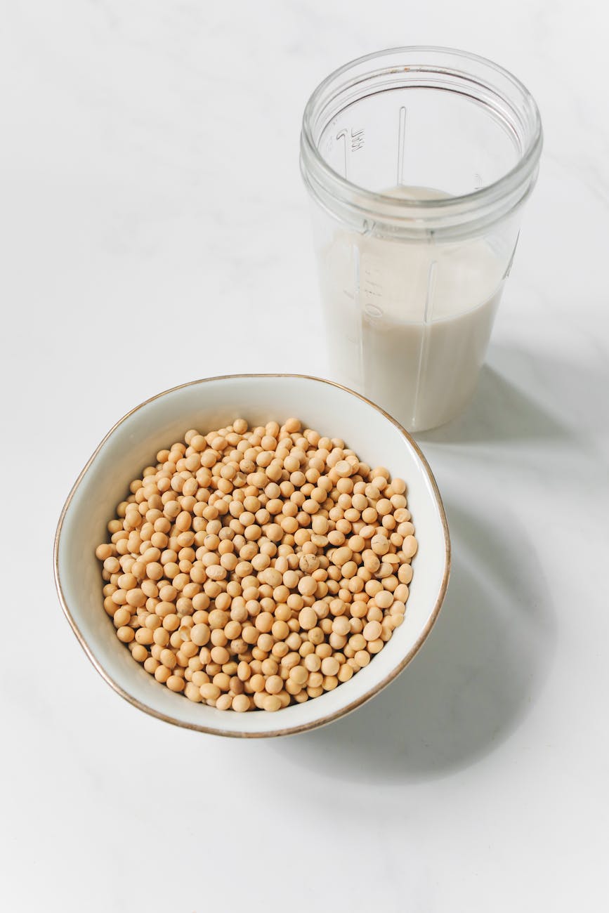 photo of soybeans on bowl near drinking glass with soy milk