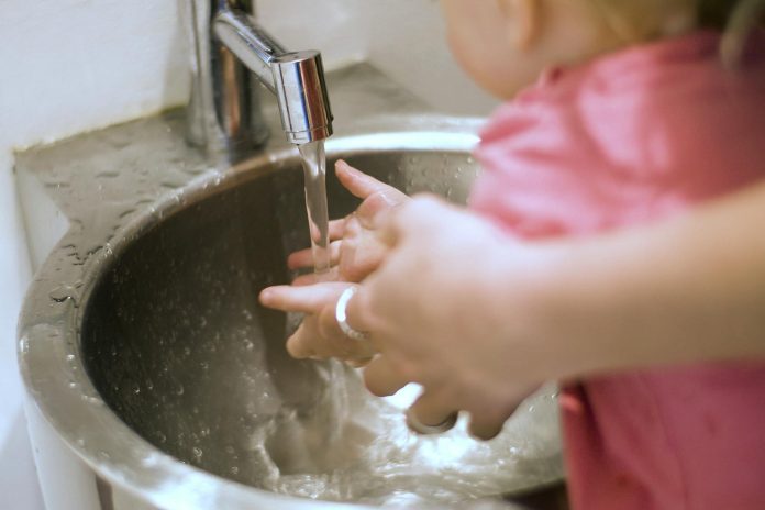 person and child washing their hands