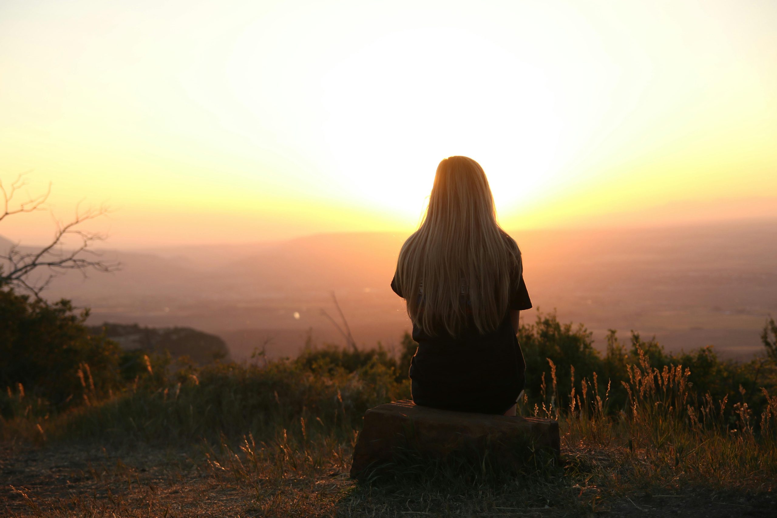 woman looking in the distance at a sunset